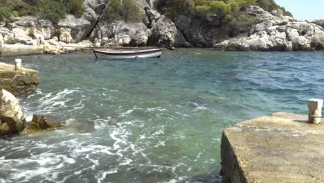 Ein-Einsames-Boot-In-Einer-Nische-Auf-Der-Insel-Mljet,-Kroatien,-Das-In-Den-Wellen-Der-Adria-Schaukelt