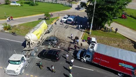 Aerial-view-of-a-traffic-accident,-passenger-car-underneath-a-tanker-truck-and-a-wrecked-lorry,-in-Mexico,-America---static,-drone-shot