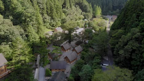 Aerial-view-of-camping-village-between-the-mountains-with-log-houses-and-cabins