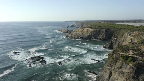 Erstaunliche-Klippen-Von-Zambujeira-Mit-Wunderschönen-Wellen,-Die-An-Einem-Schönen-Sonnigen-Und-Warmen-Tag-In-Portugal-In-Richtung-Klippen-Stürzen