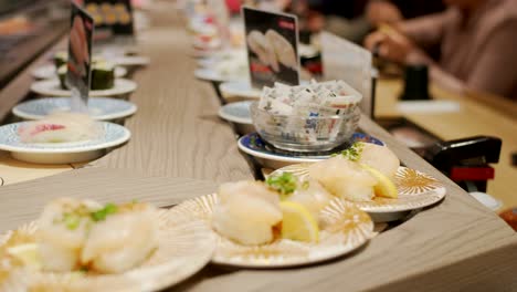 Sushi-Auf-Dem-Förderband---Verschiedene-Sushi-Serviert-Auf-Tellern,-Die-Sich-Auf-Dem-Förderband-Im-Restaurant-Kaitenzushi-In-Kyoto,-Japan,-Bewegen
