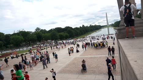 Vista-De-La-Piscina-Reflectante-Del-Memorial-De-Lincoln-Y-El-Monumento-De-Washington-Del-Memorial-De-Lincoln-Con-Multitud-De-Personas-Deambulando---Lapso-De-Tiempo