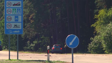 Lithuanian-border-guard-officer-control-cars-at-the-Lithuania---Latvia-border-during-crisis-measures-in-the-fight-against-the-novel-coronavirus-Covid-19,-medium-shot-from-a-distance