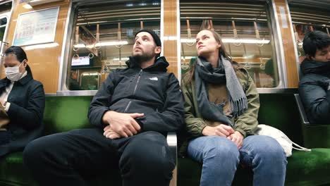 Static-Shot-of-Two-Tourists-Sitting-inside-Tokyo's-Metro,-Japan