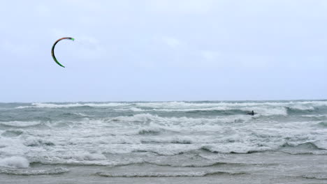 SLOW-MOTION-Kite-Boarder-Surfs-Through-Waves-On-Windy-Ocean-Water