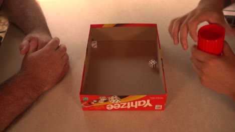 Hombre-Tirando-Dados-En-Una-Mesa-Pequeña-Durante-El-Juego