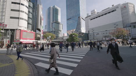 Lugareños-Japoneses-En-La-Intersección-De-Scramble-Con-Edificios-De-Gran-Altura-En-El-Fondo-En-El-Cruce-De-Shibuya-En-Tokio,-Japón-Durante-La-Pandemia