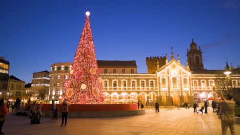 Braga-Portugal-December-2nd-2020-Lit-up-Christmas-tree-with-lights-surrounded-by-people-with-masks-in-the-main-square-of-the-historic-city-offseted-static-shot