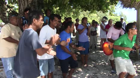 Locals-of-Fanning-Island-singing-and-dancing,-greeting-tourists
