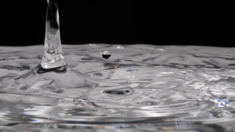 Slow-motion-of-falling-water-drops-in-pure-water-and-black-background