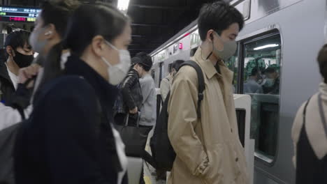 Viajeros-Con-Mascarillas-Entrando-En-Un-Tren-En-La-Línea-Yamanote-Durante-La-Pandemia-De-Covid-19-En-Tokio,-Japón