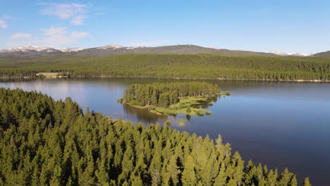 Panning-view-of-a-small-island,-which-is-normally-a-peninsula,-in-Park-Reservoir-in-Bighorn-National-Forest-in-Wyoming-in-summer