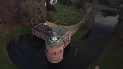 Ascenso-Aéreo-Y-Movimiento-Hacia-Atrás-Que-Muestra-El-Castillo-De-Rosendael-Con-Su-Diseño-Paisajístico,-Jardín-Y-Estructura-De-Foso