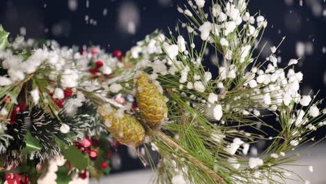 Christmas-snow-falling-on-pine-tree-branch-decoration-with-green-and-red-garland-at-winter-night