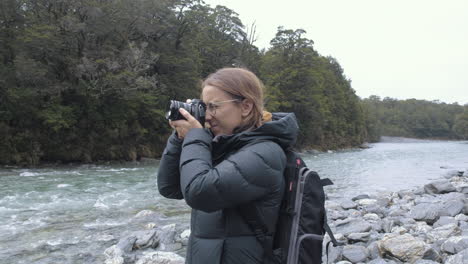 Mujer-En-Equipo-De-Senderismo-Fotografiando-Un-Lago-En-Un-Valle-En-La-Isla-Sur-De-Nueva-Zelanda