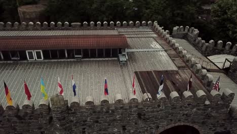 Banderas-De-Estados-Unidos,-Estonia,-Canadá,-Rusia-En-Bodega-En-Georgia-Drone-Shot