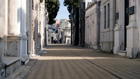 Camino-De-La-Calle-En-El-Cementerio-De-La-Recoleta-Con-Turistas-Durante-El-Día-Tiro-De-ángulo-Bajo