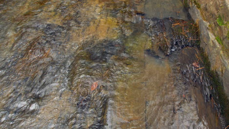Nahaufnahme-Eines-Baches,-Der-über-Eine-Glatte-Felsoberfläche-Fließt