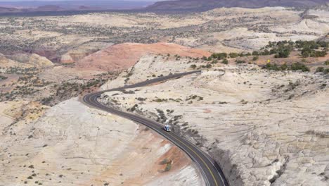 Slow-motion-shot-of-motorhome-driving-on-beautiful-windy-road-in-Utah,-USA---camera-tilting-up