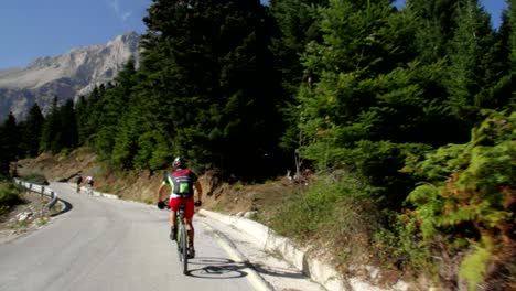 A-cyclist-celebrating-while-going-up-the-mountain-for-a-mountain-bike-marathon-in-Tzoumerka-in-Greece