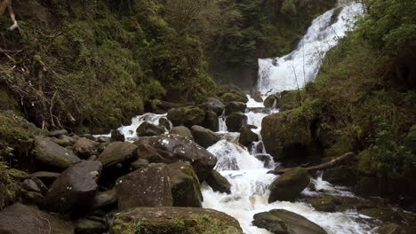 Tiro-De-Carro-Ascendente-Lento-Mientras-La-Cámara-Se-Eleva-Sobre-Las-Rocas-Y-El-Agua-Que-Fluye-En-Esta-Escena-Natural-De-Otoño---Otoño