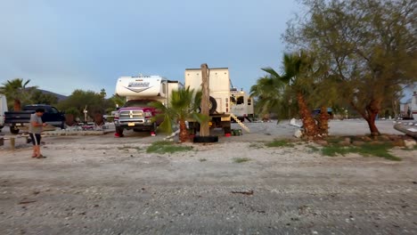 Aerial,-reverse,-drone-shot,-away-from-a-RV-park,-on-a-beach,-at-the-Cortez-sea,-on-a-sunny-evening-sunset,-in-San-Lucas-Cove,-Baja,-California,-Mexico