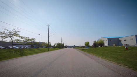 Car-driving-through-an-industrial-park-on-a-sunny-day