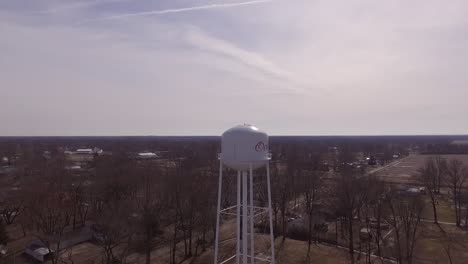 Una-Vista-Aérea-Ascendente-Desde-Un-Dron-De-Una-Torre-De-Agua-En-La-Ciudad-Rural-De-Odin-Illinois