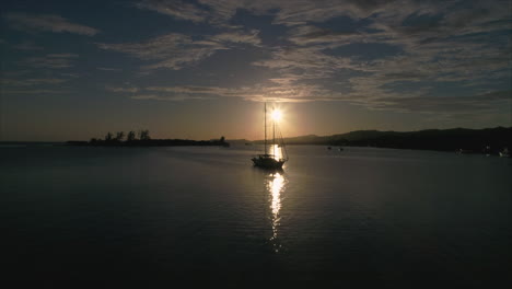 Antenne:-Sonnenuntergang-Hinter-Segelboot-Auf-Karibikinsel