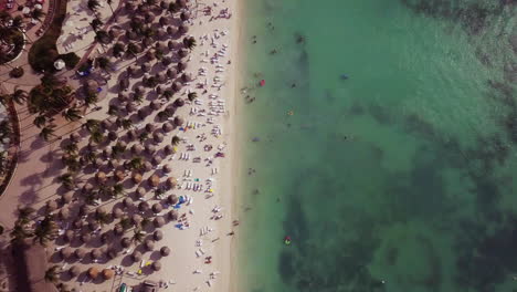 People-swimming-in-the-Caribbean-Sea-in-Palm-Beach,-Aruba