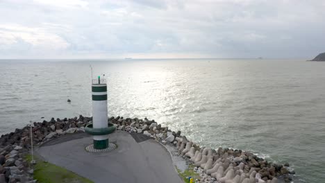 Drone-view-flying-over-the-path-of-the-lighthouse-of-Farol-Do-Molhe-Da-Barra-De-Itajaí,-Santa-Catarina,-Brazil