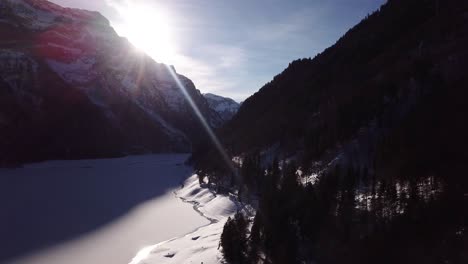 Beautiful-panorama-shot-of-snowy-mountains-in-a-valley-with-a-frozen-lake-in-Klöntal-Switzerland
