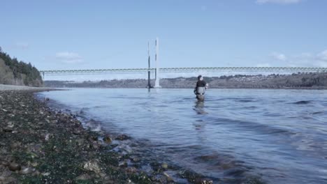 Man-Fly-fishing-at-the-Tacoma-Narrows-View-Point-at-low-tide,-Gig-Harbor,-Washington,-Puget-sound