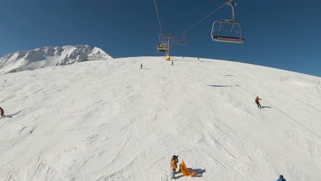 Vista-Sobre-Una-Pista-De-Esquí-Llena-De-Gente-Esquiando-Y-Un-Fotógrafo-En-El-Medio