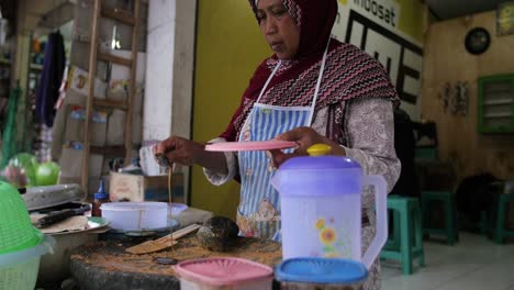 Indonesian-woman-preparing-a-traditional-Gado-Gado-meal,-Peanuts-and-rice-cakes-in-cubes,-Java