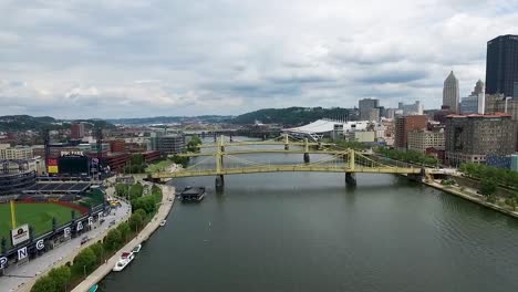 Aerial-view-of-both-sides-of-the-Allegheny-River-and-bridges-running-through-the-city-of-Pittsburgh,-Pennsylvania-Concept:-urban,-cityscape,-sporting,-fields,-drone