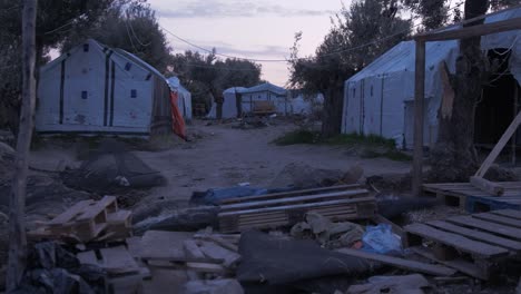 Refugee-camp-makeshift-shelters-at-dusk-handheld-pallet-wood-debris