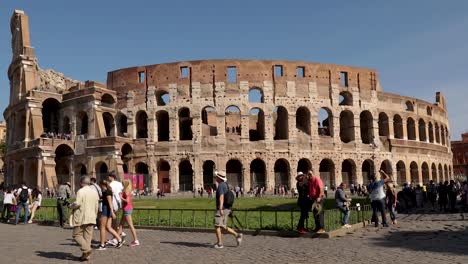 Aufschlussreiche-Weitwinkelaufnahme-Des-Kolosseums-Von-Rom-Mit-Touristen,-Die-Zu-Fuß-Gehen-Und-Selfie-Fotos-Machen