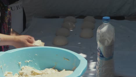 Afghan-refugee-women-shaping-dough-into-circular-balls-to-bake-bread-in-traditional-Tandoor