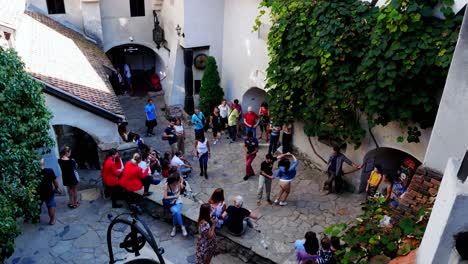 Neigen-Sie-Die-Aufnahme-Von-Jungen-Leuten,-Die-An-Einem-Sommertag-Im-Bran-Castle-Bebop-Und-Swing-Tanzen