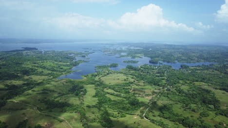 aerial-view-of-green-filds,-trees,-gatun-lake-on-sunny-day