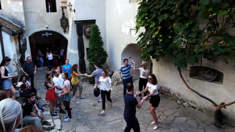 Tilt-up-shot-of-Young-couples-dancins-swing-in-the-courtyard-of-Bran-castle