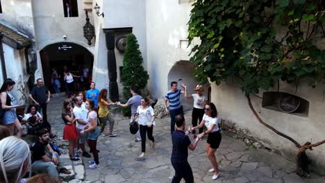 Tiro-Inclinado-Hacia-Arriba-De-Parejas-Jóvenes-Bailando-Columpio-En-El-Patio-Del-Castillo-De-Salvado