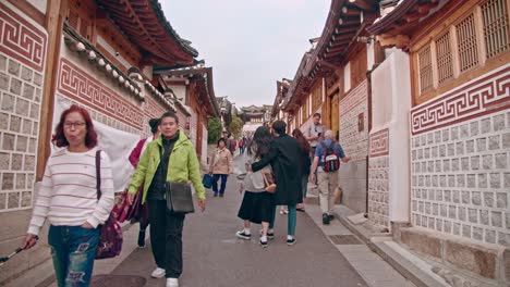 Touristen,-Die-Im-Dorf-Bukchon-Hanoak-In-Seoul-Spazieren-Gehen-Und-Fotos-Machen-Touristen,-Die-In-Einem-Traditionellen-Koreanischen-Dorf-Reisen