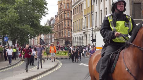 Los-Caballos-De-La-Policía-Guían-A-Antifa-Mientras-Protestan-Contra-Tommy-Robinson-En-Londres,-Reino-Unido