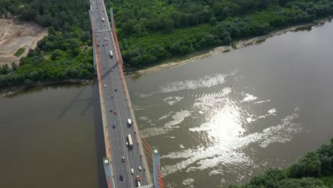 Aerial-shooting-from-flying-drone-car-traffic-on-modern-highway-bridge-over-river