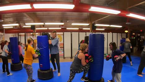 Adult-students-practicing-rapid-strikes-and-punches-while-participating-in-a-self-defense-class-at-martial-arts-school