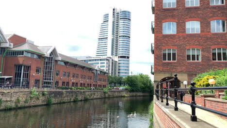 Statische-Aufnahme-Des-Flusses-Aire---Bridgewater-Place-An-Einem-Hellen-Sommertag-In-Leeds,-Yorkshire,-Mit-Einer-Schwanenfamilie,-Die-Auf-Dem-Fluss-Schwimmt