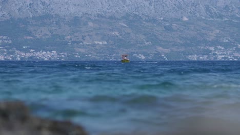 Ein-Kleines-Gelbes-Freizeitboot-Schwimmt-Auf-Dem-Ozean-Vorbei,-Mit-Menschen,-Die-Einen-Tagesausflug-Genießen