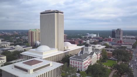 Vuelo-Aéreo-Lejos-De-Los-Edificios-Nuevos-Y-Antiguos-Del-Capitolio-Para-Revelar-El-Centro-De-Tallahassee,-Florida